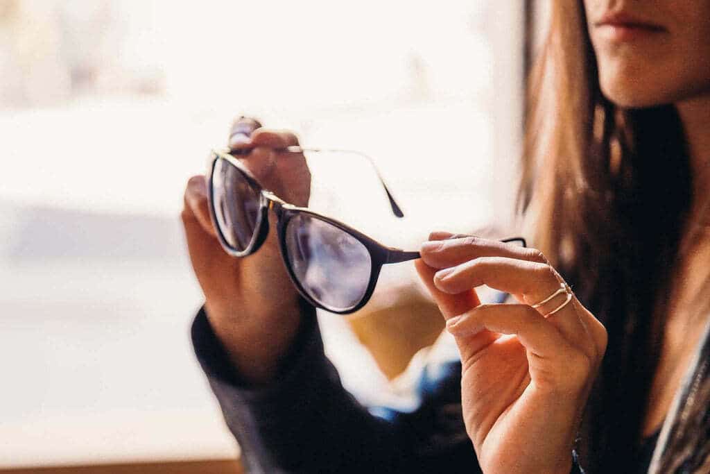 femme qui regarde ses lunettes