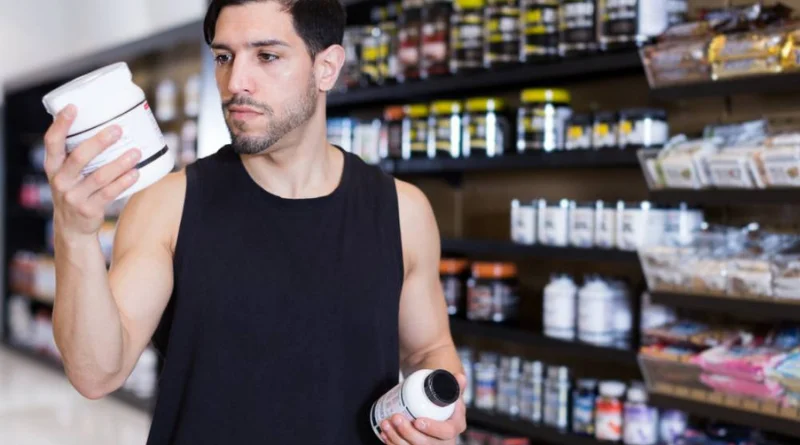Homme choisissant un complément alimentaire pour sportif