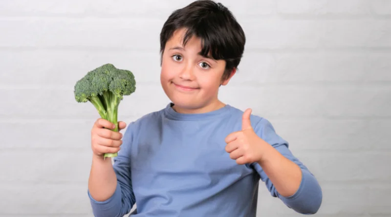 Enfant végétarien avec un brocolis en main